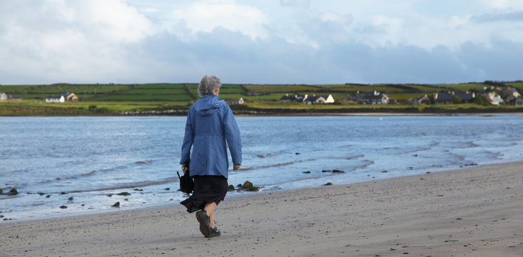 Old irish lady on a beach in Ventry on Dingle peninsula