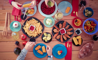 People with drinks while sitting at the dining table. Food on the table. Food on the table. People eat fast food.