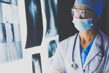 Image of attractive woman doctor looking at x-ray results.