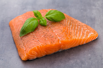 Fresh salmon fille with spice on the grey background.