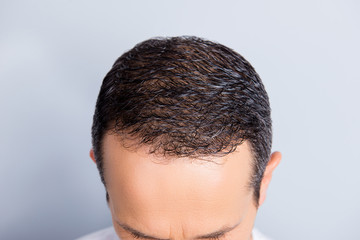 Obraz premium Top view portrait of brunet, trendy, neat, experienced man's perfect smooth soft dry, oiled, clear hair isolated on grey background, result after fighting with dandruff