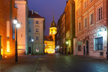 Royal Castle and beautiful street in Old Town during evening blue hour, Warsaw, Poland.