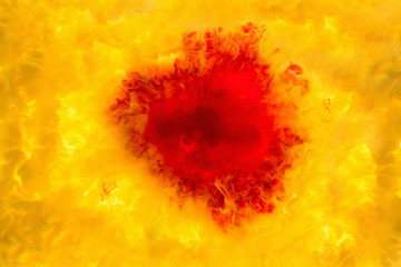 ink in the water. A splash of red yellow paint. Abstract background