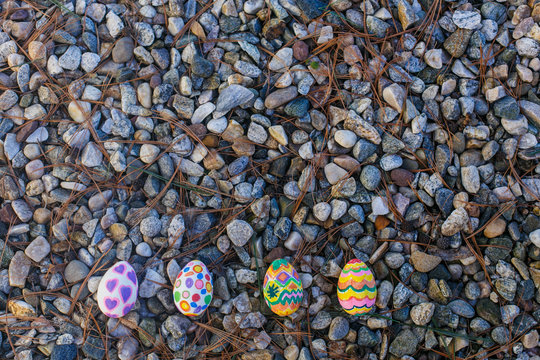 Four easter eggs lie on the pebbles
