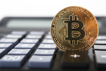 Bitcoin on the keyboard of the calculator. Shallow depth of field. A visual representation of digital cryptocurrencies. Bitcoin are fully dematerialized and decentralized electronic currencies