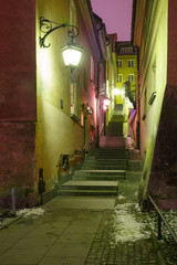 Fototapeta na wymiar Beautiful narrow street with stairs in Old Town during evening blue hour, Warsaw, Poland.