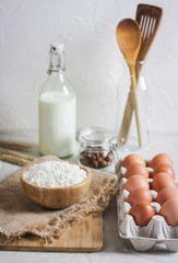 Baking ingredients: flour, eggs, nuts, spiceson white  table.