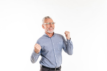 Happy old man making winner gesture isolated