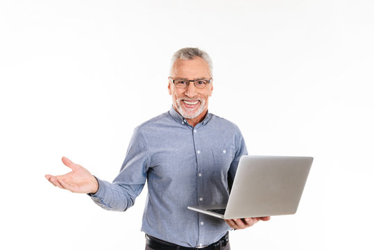 Happy man holding laptop computer and smiling to camera isolated
