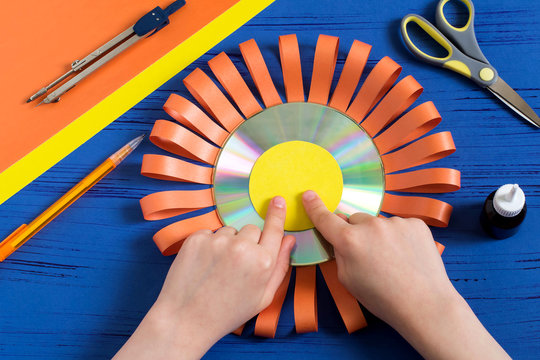 Child makes smiling sun from CD. Step 8