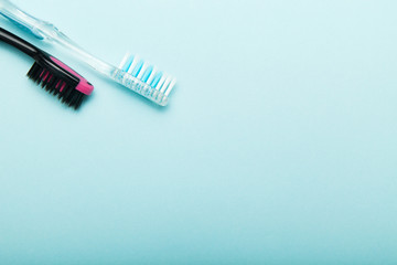 Colorful toothbrushes isolated on blue background. Empty copy space for text.