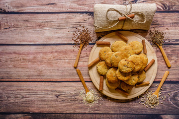 Freshly baked scones on a wooden plate with cinnamon sticks and different  spices on wooden spoons