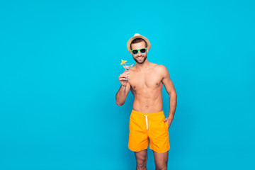Attractive, cheerful, stunning, perfect, harsh, virile man in yellow shorts, having cocktail with...