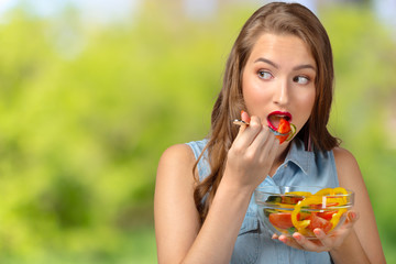 Smiling woman holding glass bowl with salad.