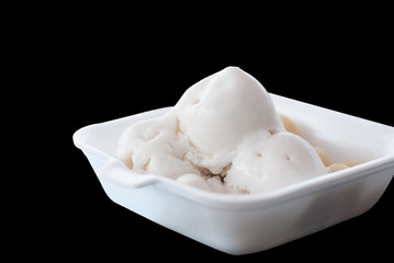 Thai style coconut ice-cream in white foam package is isolated on black background