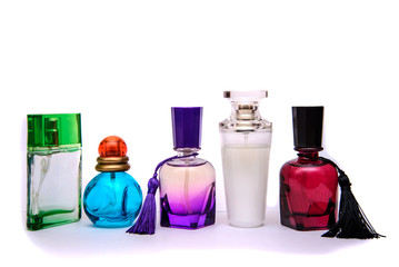 Multicolored bottles of perfume on a white background