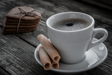 White cup of coffee on a natural old wooden background with biscuits. Selective focus. With copy space