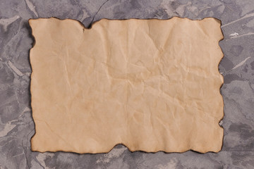 One old blank crumpled rectangle burnt sheet of paper on gray old broken cement