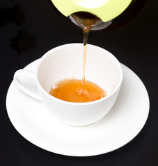 Tea in a cup on a black background