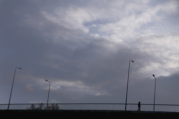 Fototapeta na wymiar Silhouette person on the bridge with street lanterns