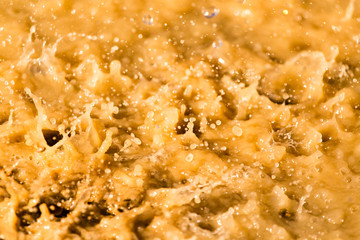 Rain drops fall into a dirty puddle