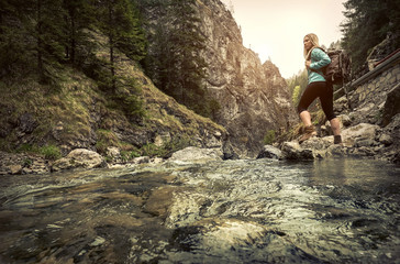 Woman hiking around mountains near the river at spreeng time.
