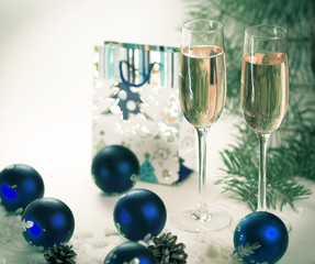 two glasses with champagne and gift on the Christmas background 