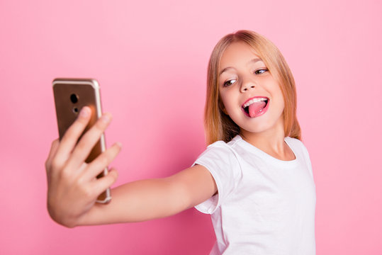 Addiction lifestyle leisure style trend play game concept. Close up portrait of cute lovely sweet charming with toothy smile taking selfie girl on mum's phone isolated on pink background