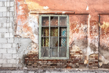 Fototapeta na wymiar old window in an ancient brick wall in an abandoned farm barn