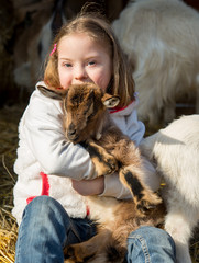 Down syndrome girl playing with baby goat