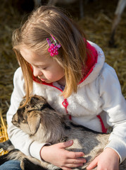 Down syndrome girl playing with baby goat