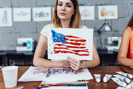 Smiling female artist showing her works, American flag drawn with watercolor technique