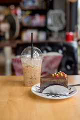 ice coffee take away and cake on wooden background