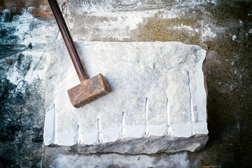 Closeup of a large piece of marble and a hammer after splitting.