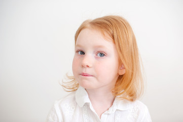 Pensive girl in white shirt on the white background