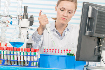 Experiments in the chemical laboratory, Female researcher using her test tube in a laboratory