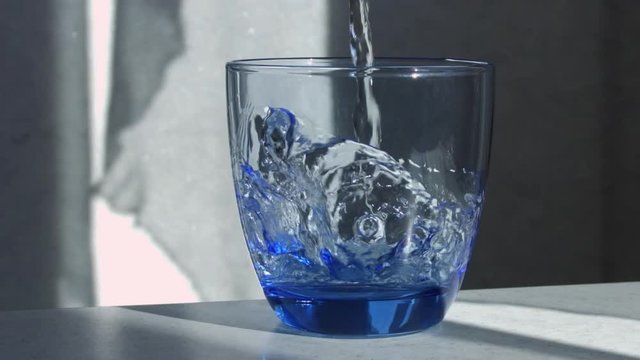 Water is Poured Into a Glass Beaker. Water is poured into the transparent glass. Water pours slowly. Stop Motion