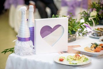 table with glasses of sand prepared for sand ceremony during wedding of bride and groom