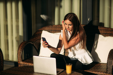 Young beautiful girl use a laptop during a break at work. Summer sunny day