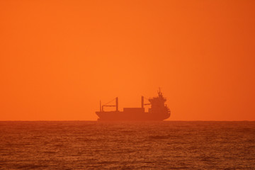 Silhouette of ship on the ocean at sunrise