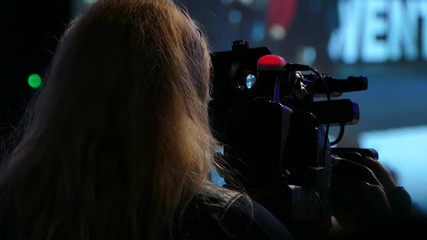 Girl video operator. Videography of the performance on stage. Broadcast the video to the big screen. Live on TV.