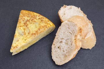 potato omelet with bread on black background