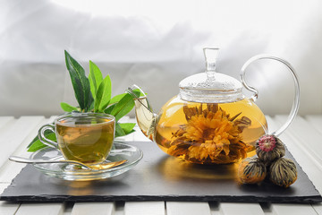 Exotic green tea with flowers in glass teapot