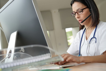 Medical secretary typing report on deskop computer