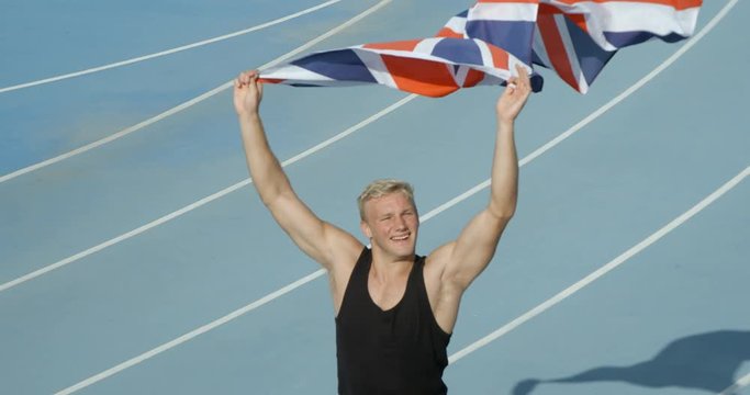An Athlete celebrates with the national flag of Great Britain.