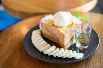 Honey toast topping by vanilla ice-cream  slice with whipping cream and banana, selective focus