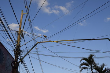 Postes e fios tampando um céu azul
