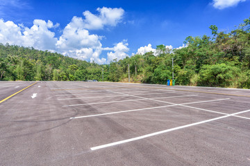 Empty parking lot with forest and beautiful blue sky. © yotrakbutda
