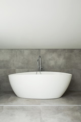 Fototapeta na wymiar White bathtub in simple bathroom