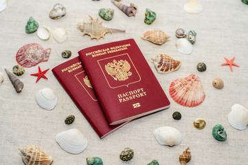 Passport and seashells on the background of sand, travel concept